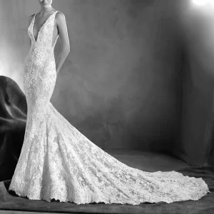 Elegant vit broderad bröllopsklänning, v-skuren fram och bak, v-skuren längst med revbenen, sjöjungfrudesign med långt släp av märket Pronovias.